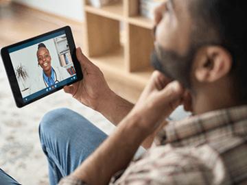 Man holding his throat whilst on a GP video call