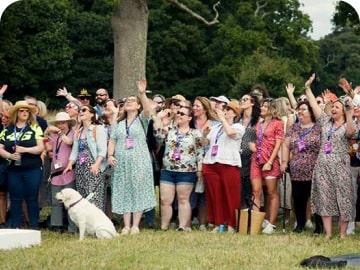 A group of Simplyhealth colleagues outside cheering and waving