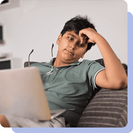 Teenage boy looking stressed at laptop