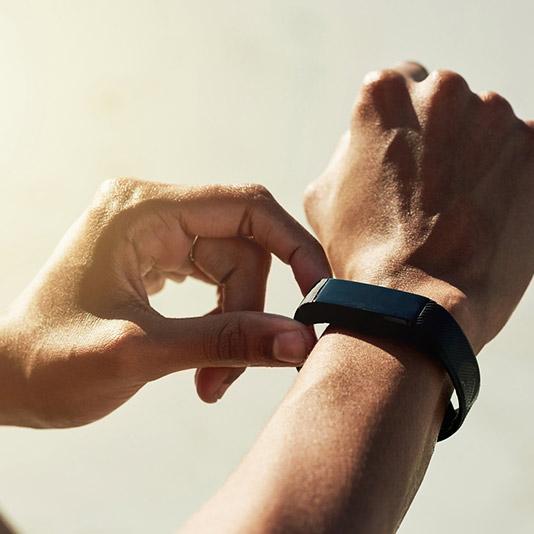 A man adjusting his fitness tracker on his wrist