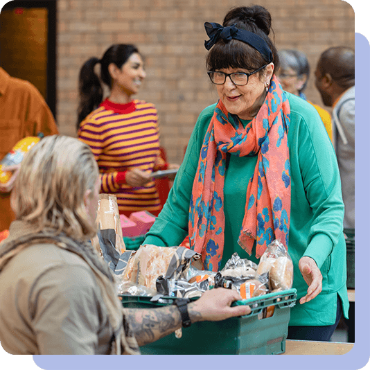 Woman handing over crate of bread at a food bank