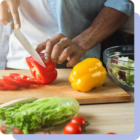 Man chopping peppers and preparing a salad