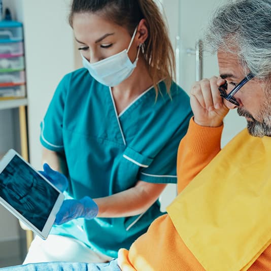 Dentist showing x-ray to patient