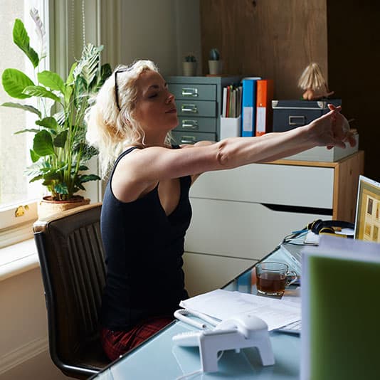 Woman stretching at WFH setup