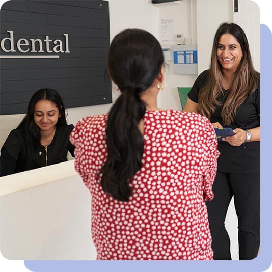 Woman laughing with the dentist and receptionist