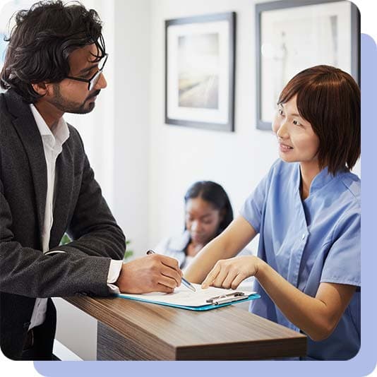 Man at the dentist reception filling in form