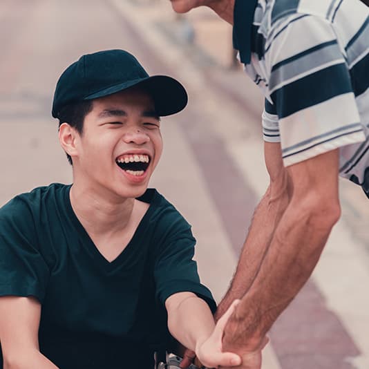 Carer taking smiling boy out for walk
