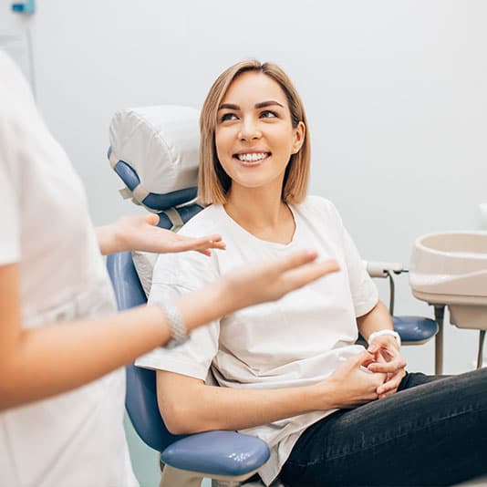 Lady patient smiling at denplan dentist in clinic