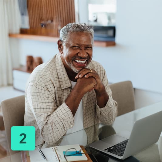 3 - man smiling while claiming back money on his health plan using laptop