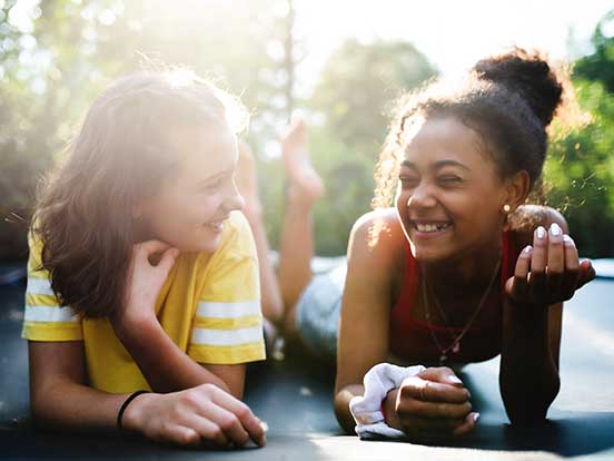 Teenage girls talking on trampoline