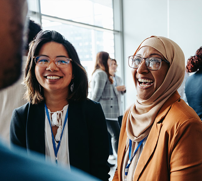 Two women laughing at work conference